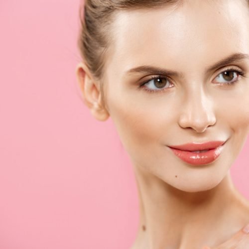 Skin Care Concept - Charming young caucasian woman with perfect makeup photo composition of brunette girl. Isolated on pink background with Copy Space.